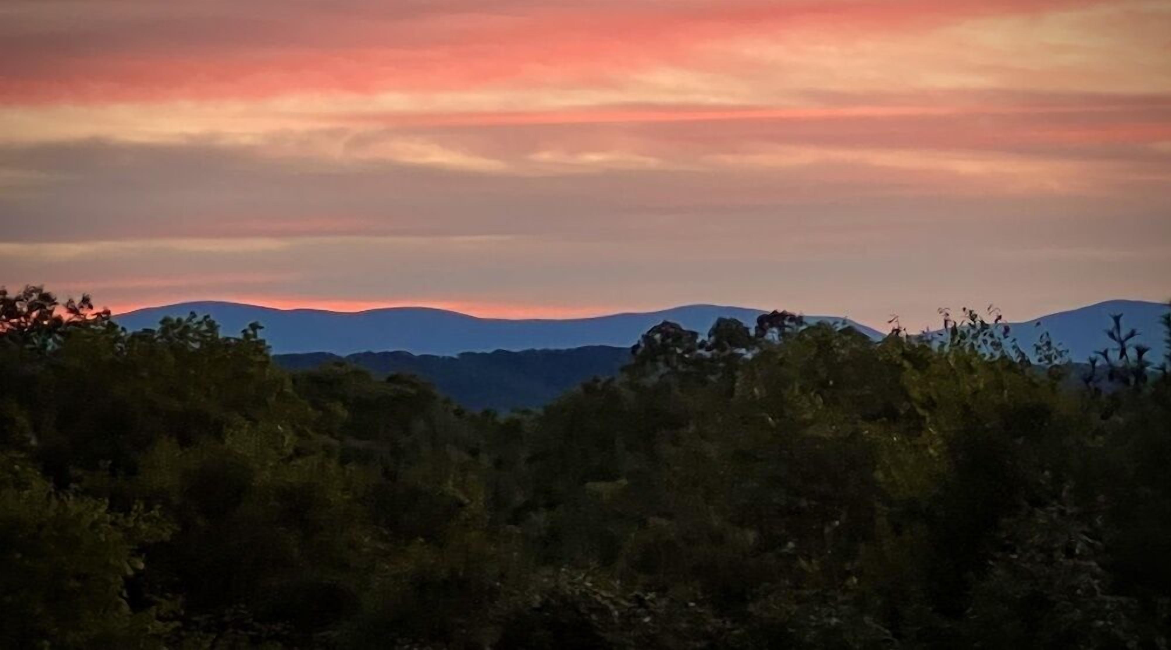 Un paisaje montañoso con atardecer.