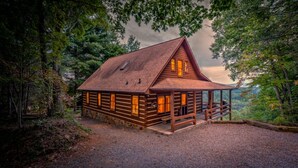 A log cabin with a steep roof, large windows, and a porch. - Rocky Top- Pet Friendly | VIEWS VIEWS VIEWS! | Large Screened Porch (Morganton)