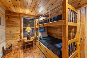 A wooden cabin interior with bunk beds, a desk, and a window with a view. - Row Harder- Pet Friendly | Screened Porch | Riverside| Guest House (Blue Ridge)