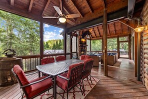 A wooden deck with a table and chairs, a fireplace, and a ceiling fan. - Row Harder- Pet Friendly | Screened Porch | Riverside| Guest House (Blue Ridge)