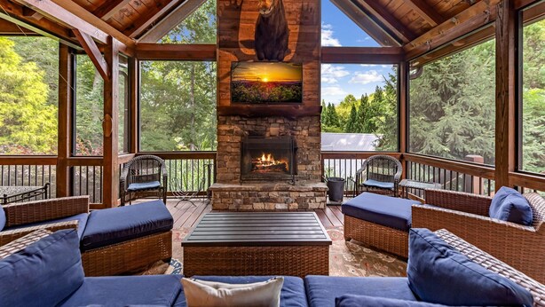 Un espacio al aire libre acogedor con mobiliario de mimbre y una chimenea de piedra.