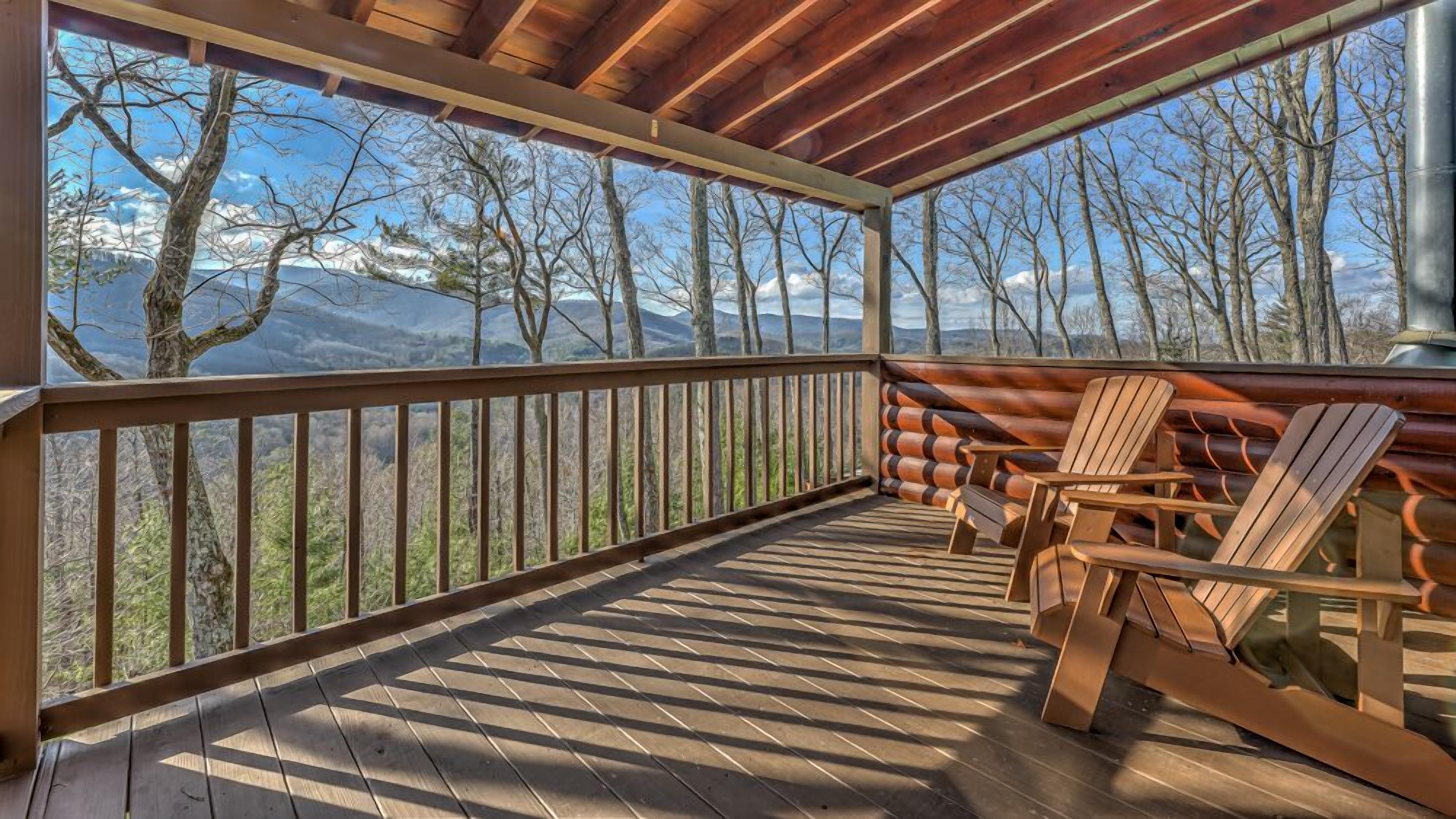 Una terraza de madera con vistas a montañas y árboles.