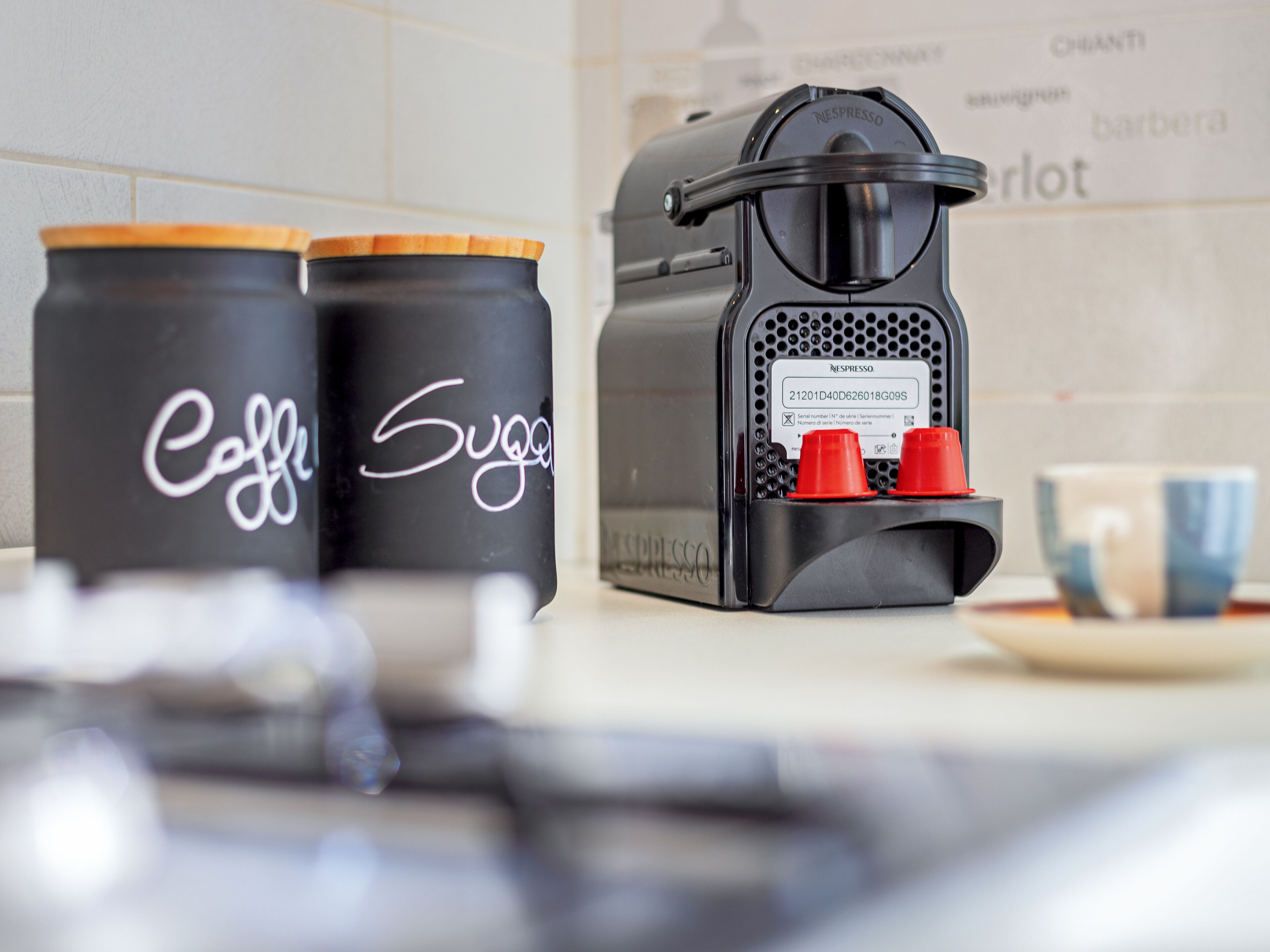 Une machine à café avec deux capsules rouges et deux récipients noirs sur lesquels sont inscrits les mots « Café » et « Sucre ».