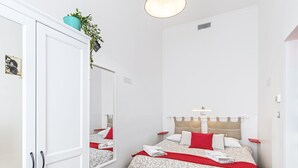 A bedroom with a bed, a wardrobe, a mirror, and a ceiling light. - Very central - Via Po Torino (Torino)