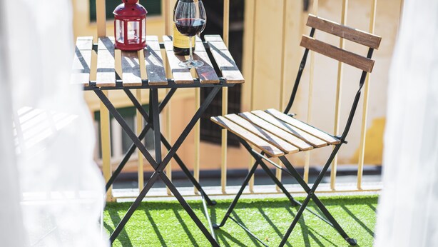 A balcony with a table, a chair, a bottle of wine, and a red lantern. - Very central - Via Po Torino (Torino)