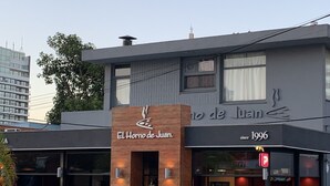 A restaurant named "El Hormo de Juan" with outdoor seating and a parking sign. - Lindo apartamento a una cuadra de la Playa Brava. (Punta del Este)
