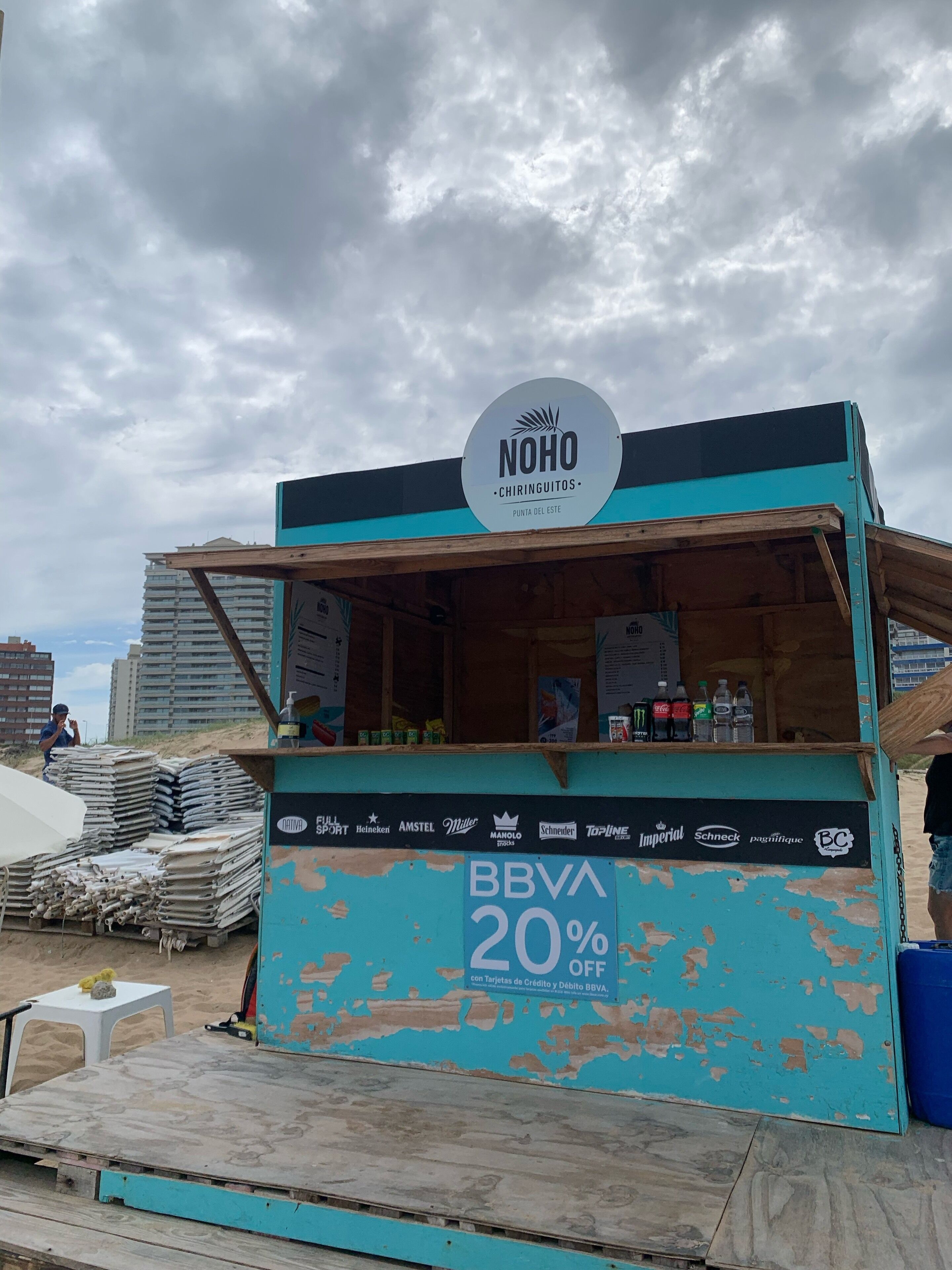 Un pequeño quiosco con un letrero que dice "NOHO CHIRINGUITOS" y una oferta de 20% de descuento.