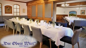 A dining area with long tables set for a meal, wooden paneling on the walls, and framed artwork on the walls. - Der Obere Wirt zum Queri (Andechs)