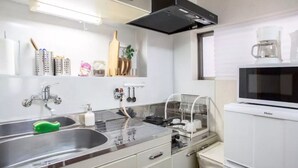 A modern kitchen with stainless steel appliances, a microwave, and a dish drying rack. - Not Ninja Osaka Namba 1 (Osaka)