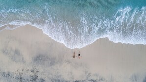 An aerial view of a beach with two people lying on the sand. - Adiwana Warnakali Resort (Penida Island)