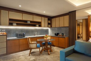 A modern kitchen with wooden cabinets, a round dining table, and blue chairs.