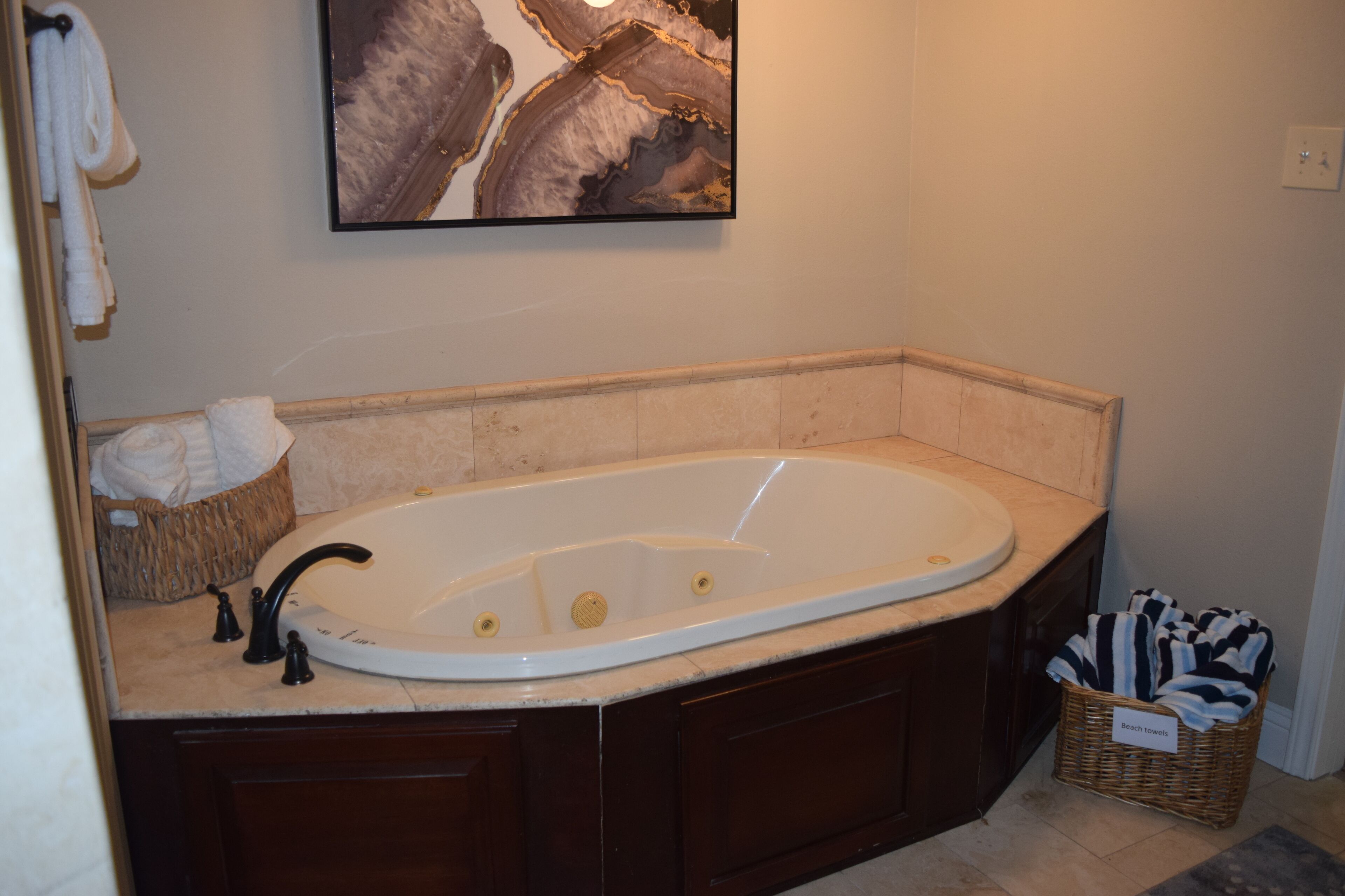 A bathroom with a freestanding bathtub, a wicker basket, and a towel rack.