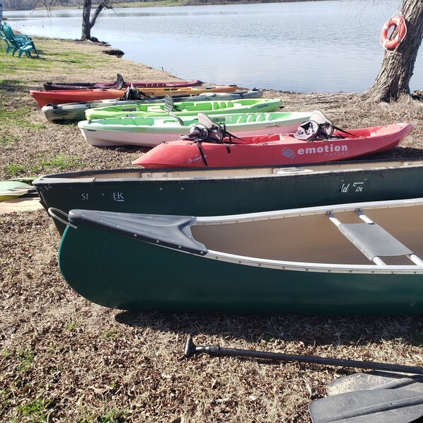 A row of kayaks and a paddleboard by a lakeside. - Gorgeous Hidden gem Lake front Studio. Come rewind. Pet friendly (Little Elm)