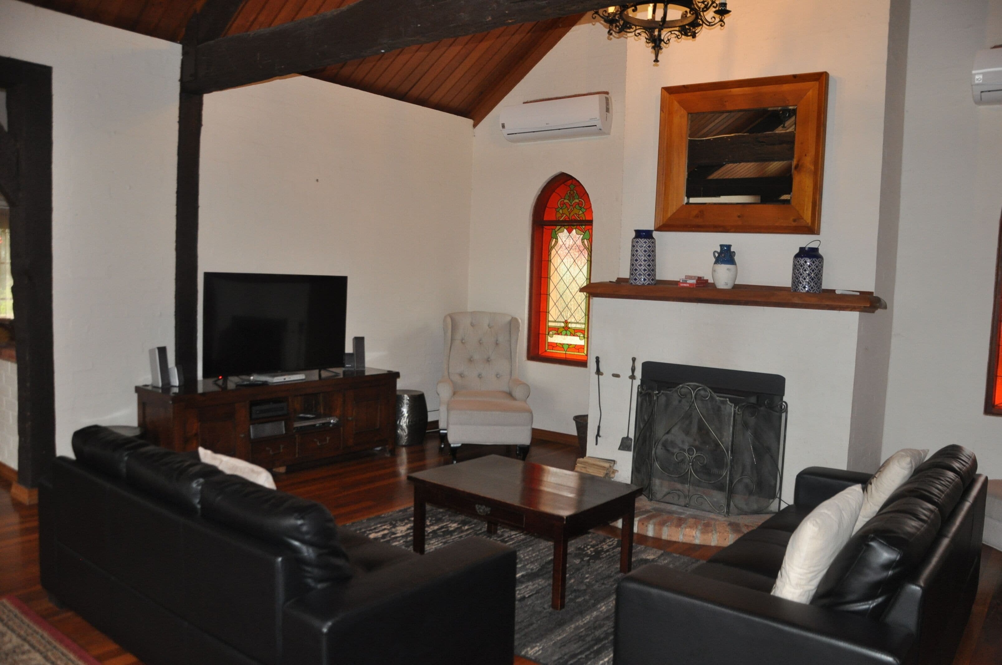A living room with a fireplace, a television, and a comfortable seating area.