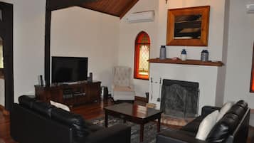 A living room with a fireplace, a television, and a comfortable seating area.