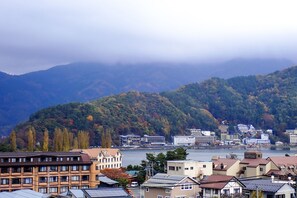 A coastal town with buildings along the waterfront, a mountain backdrop, and a body of water.