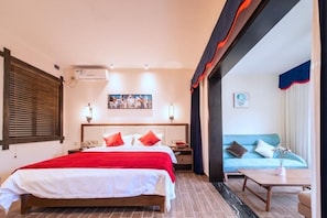 Una habitación de hotel con cama, mesitas de noche, un sofá y una mesa de centro.