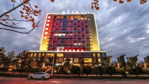 A multi-story hotel with a modern facade, illuminated windows, and a prominent entrance. - Zijing International Hotel (Enshi)