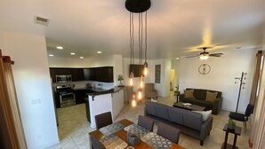 Un espacio moderno para vivir con cocina, comedor y sala.