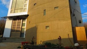 A modern building with a curved facade, large windows, and a gated entrance. - Hong Hu Ju Captain Sung's House (Baisha)