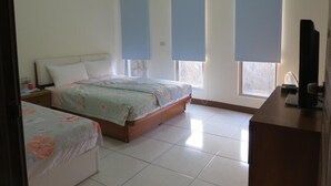 A bedroom with two beds, a desk, and a TV. - Hong Hu Ju Captain Sung's House (Baisha)