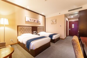 A hotel room with two beds, a desk, a chair, and a couch. - Hubei Konggang Business Hotel (Wuhan)