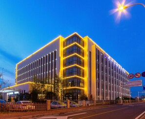A modern building with a prominent entrance and a gated parking area. - Hubei Konggang Business Hotel (Wuhan)