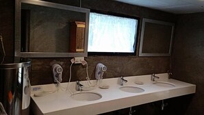 Une salle de bain avec deux lavabos, un miroir et une fenêtre.