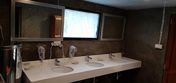 Un baño con dos lavamanos, un espejo y un ventanal.