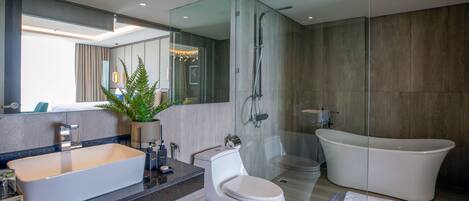 A modern bathroom with a large sink, toilet, and freestanding bathtub.