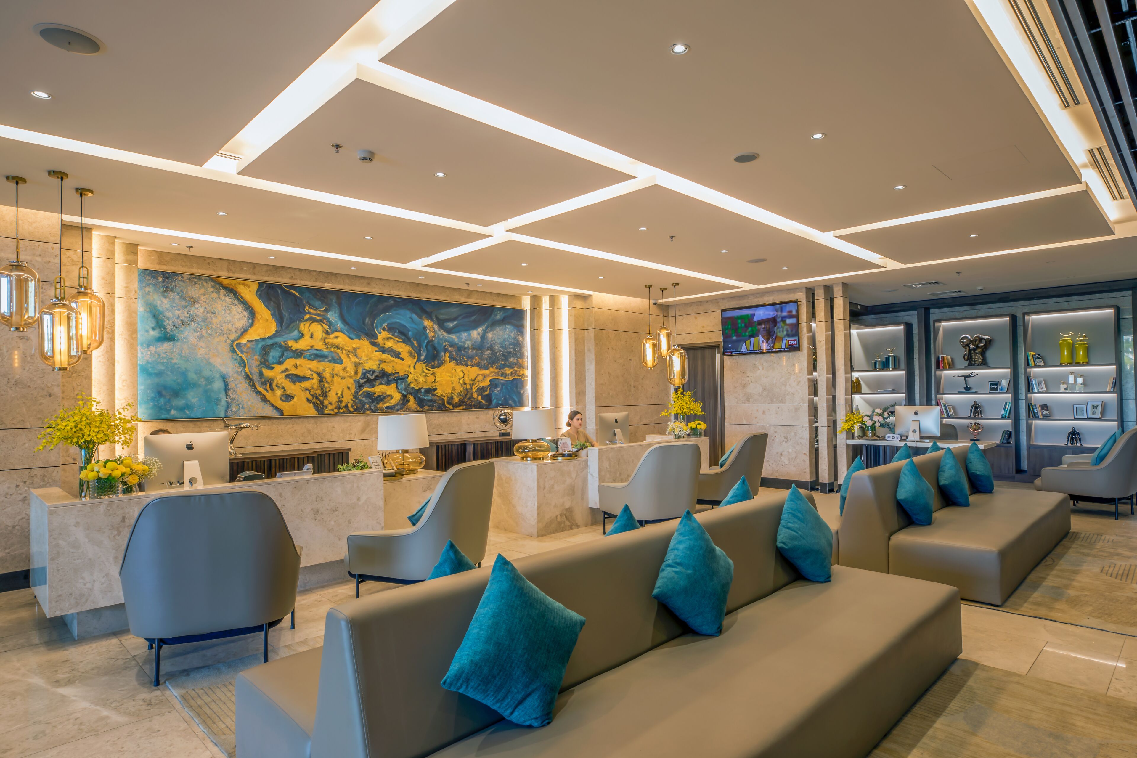 A modern lobby with a reception desk, seating area, and a large abstract painting on the wall.