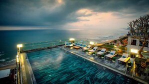 A rooftop infinity pool with lounge chairs and a view of the ocean. - Minh Toan SAFI Ocean Hotel (Da Nang)