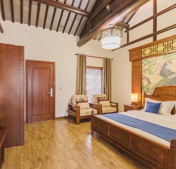 A traditional room with a wooden bed, two chairs, a wooden wardrobe, and a decorative wall. - Floral Hotel Rainview Pavilion (Suzhou)