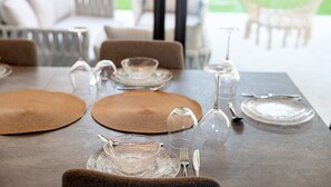 A dining table set with brown placemats, clear glassware, and silverware. - Dov Garden apartment with private pool (Tiberias)