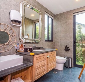 Une salle de bain moderne avec un grand miroir, un lavabo et des toilettes.