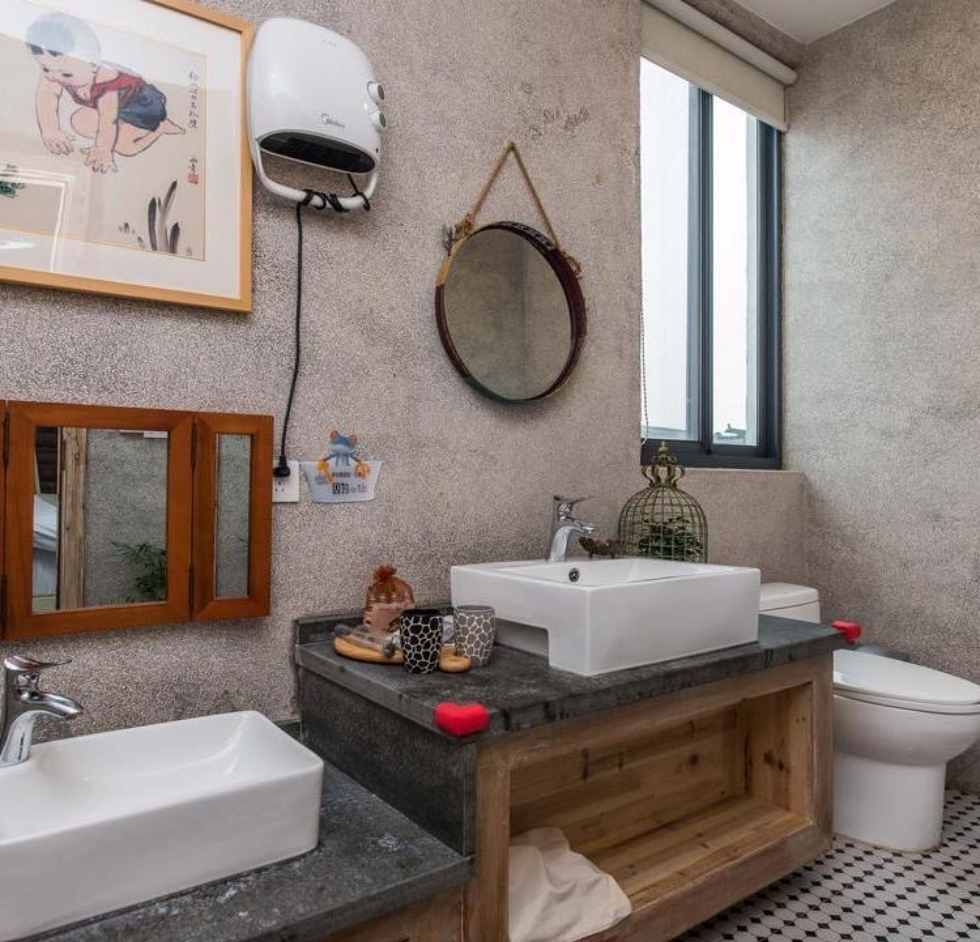 Une salle de bain équipée d’un grand miroir, d’un sèche-cheveux, d’un lavabo et de toilettes.