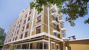 A multi-story residential building with balconies, large windows, and a covered entrance area. - Wises Hotel (Chachoengsao)