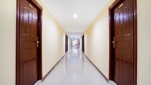 A long, narrow hallway with two doors on each side, each marked with a number. - Wises Hotel (Chachoengsao)