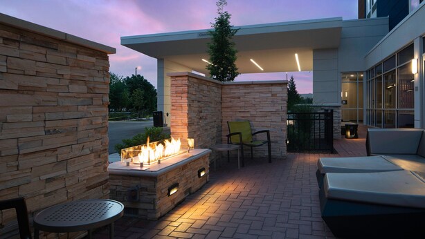 An outdoor patio with a fire feature, seating, and a covered area. - SpringHill Suites by Marriott Winchester (Winchester)