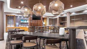 A modern hotel lobby with a large dining area, wooden accents, and contemporary lighting fixtures. - SpringHill Suites by Marriott Winchester (Winchester)