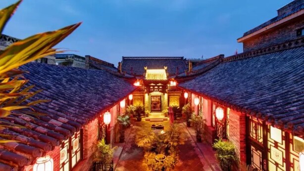 A traditional courtyard with tiled roofs, a central gate, and lanterns. - Floral Hotel Sui Yuan Pingyao (Jinzhong)