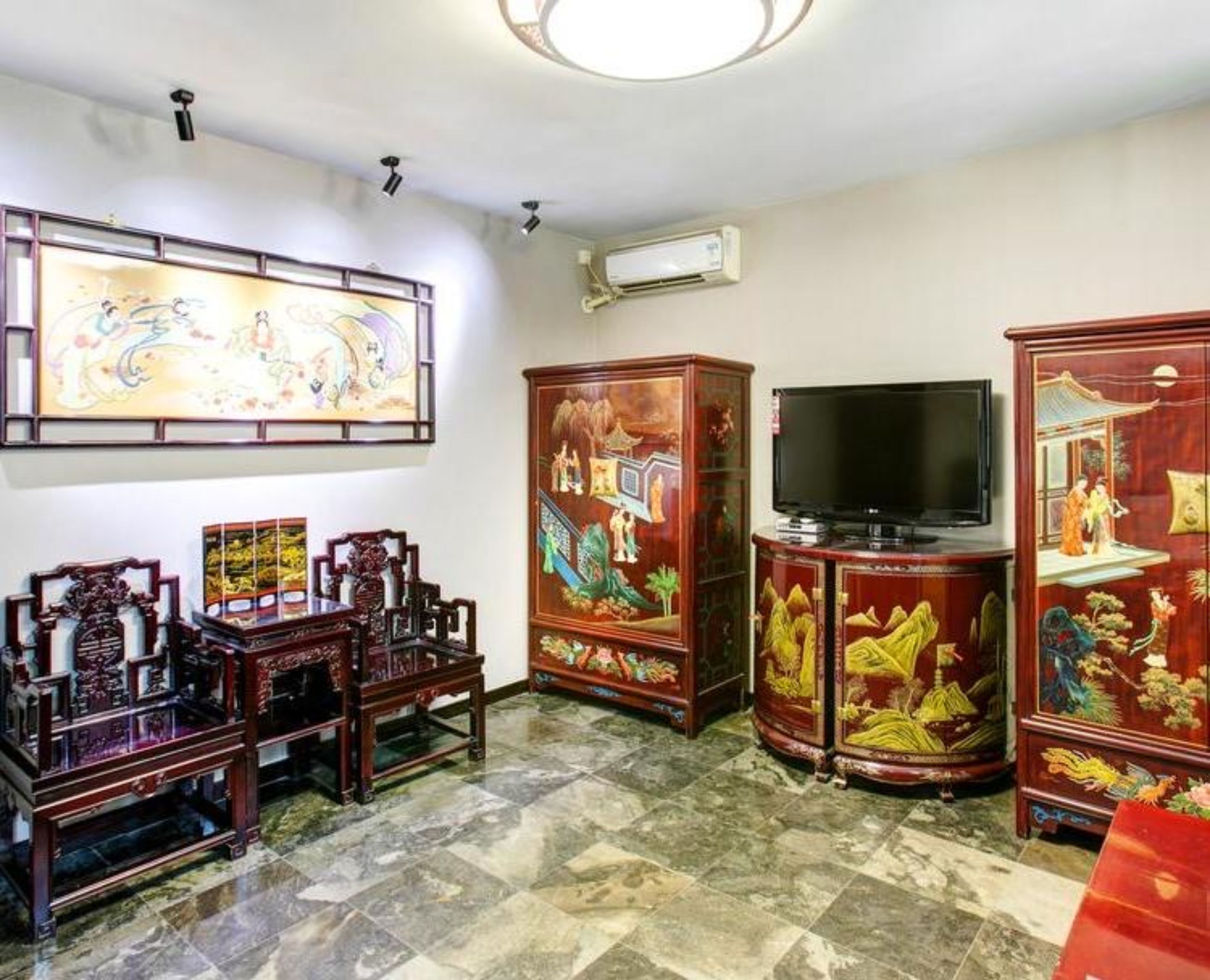 Una habitación con muebles tradicionales, televisión de pantalla plana y obras de arte en las paredes.