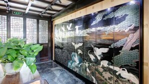 A traditional Japanese room with sliding doors depicting a nature scene, a wooden floor, and a potted plant. - Floral Hotel Sui Yuan Pingyao (Jinzhong)