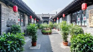 A courtyard with traditional architecture, featuring tiled roofs and red lanterns. - Floral Hotel Sui Yuan Pingyao (Jinzhong)