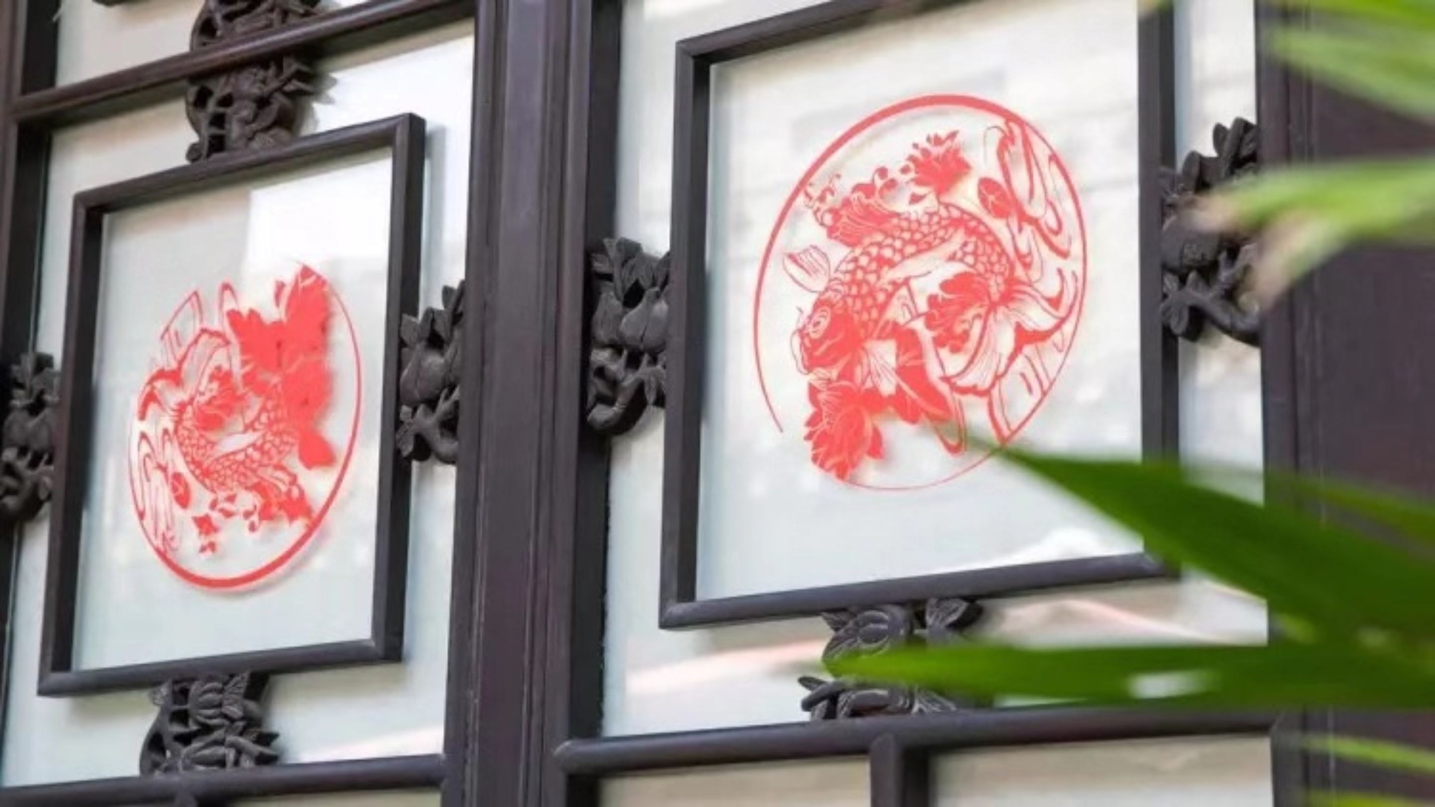 A building facade with traditional red Chinese characters and dragon motifs framed in black.