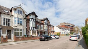 A residential street with houses, parked cars, and a clear sky. - Westland House Guest house (Watford)