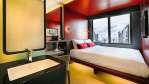 A modern hotel room with a large bed, a bedside table, a mirror, and a window offering a city view. - The Upper House Hotel (Simpang Ampat)
