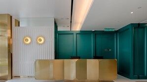 A reception desk with a modern design, a teal-colored wall, and a sign that reads "KELUAR". - The Upper House Hotel (Simpang Ampat)