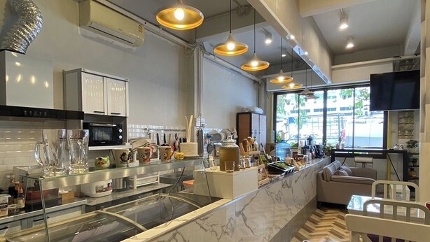A modern kitchen with marble countertops, pendant lighting, and a herringbone floor pattern. - Lemon Siam Hostel Free Breakfast (Bangkok)