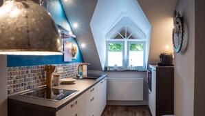 A kitchen with a window, a radiator, and a wooden floor. - Das Haus Am Markt (Traben-Trarbach)